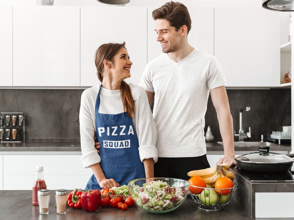young couple in the kitchen prepares pizza